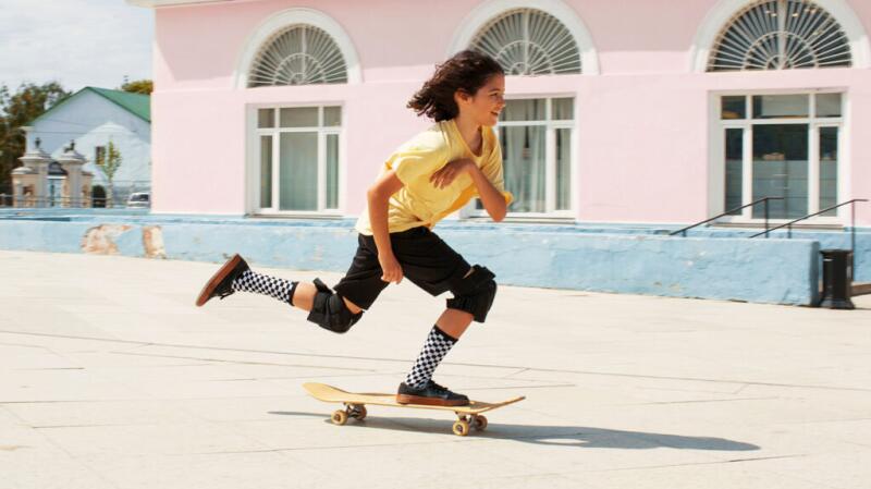 Young girl skateboarding on sunny day
