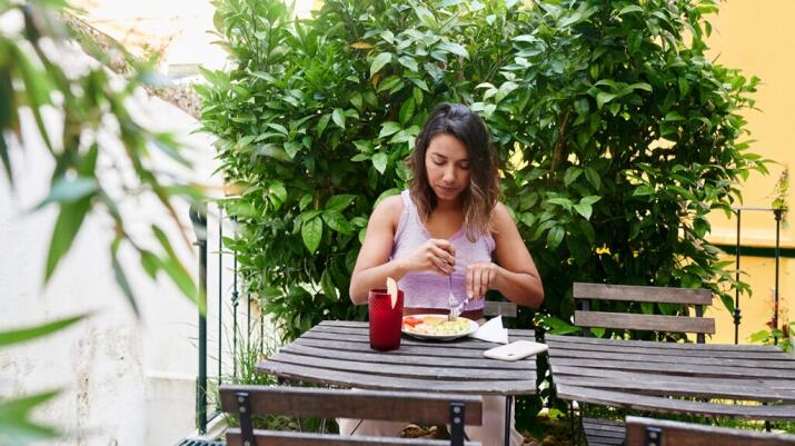 Woman eating breakfast on her patio