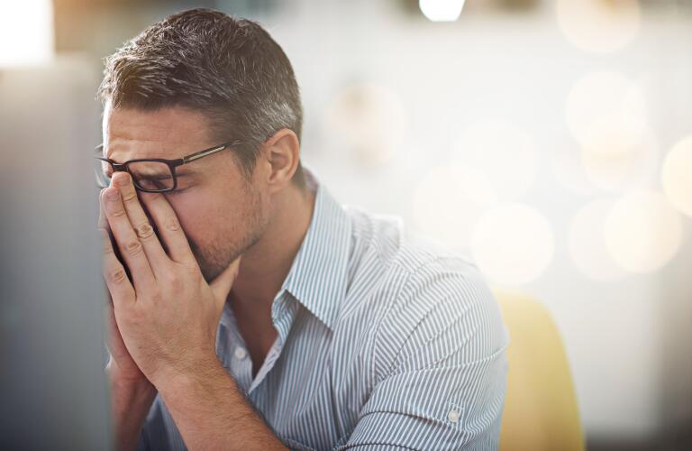 exhausted-man-with-hands-in-face