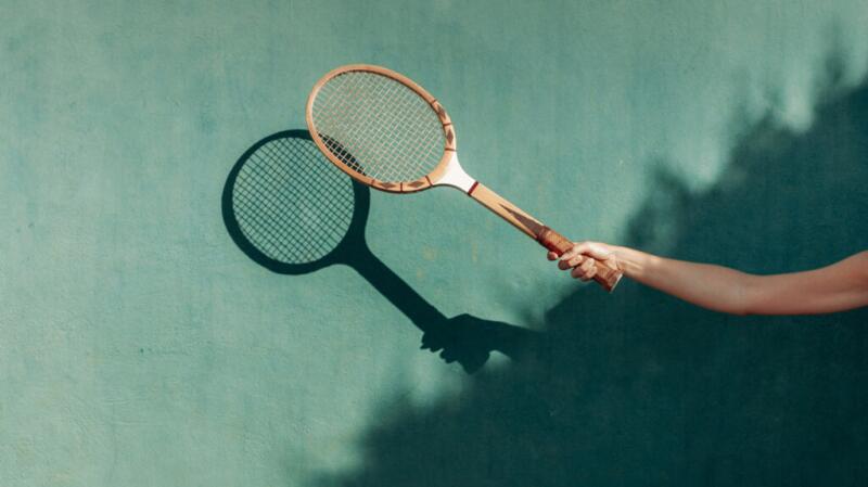 A person is holding a tennis racquet.