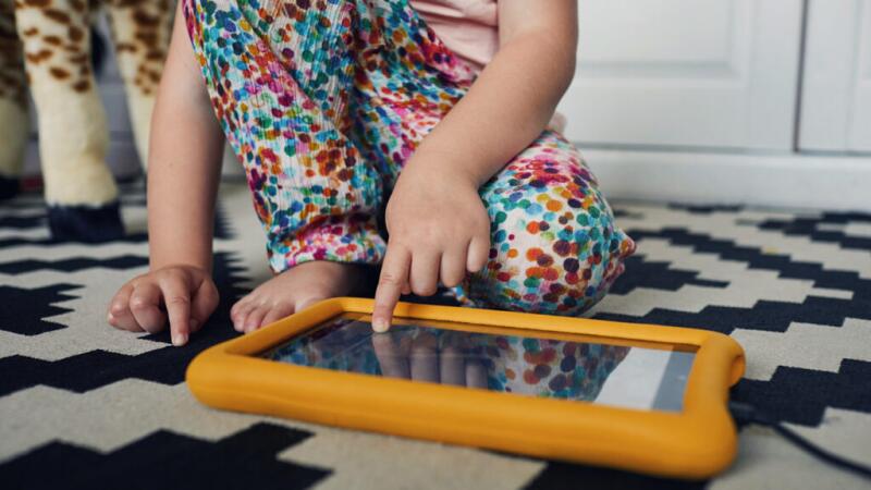 A young child is using a tablet device.
