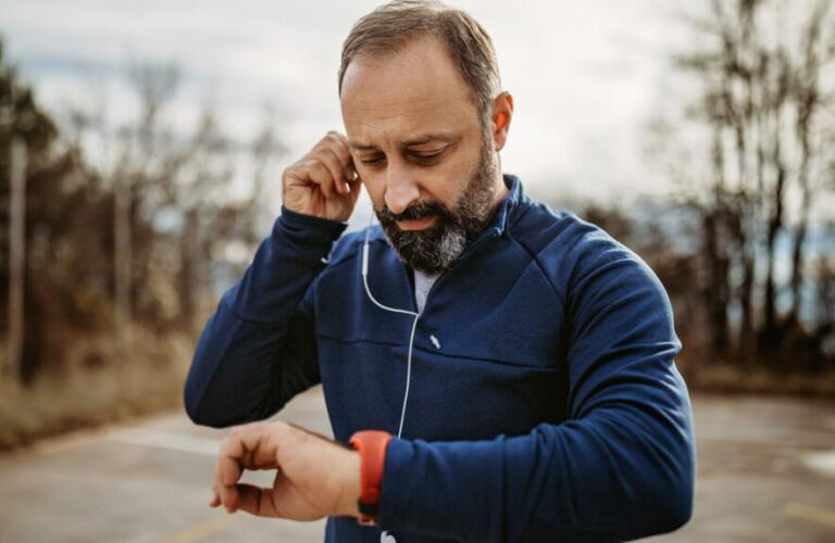 a man is running and checking his pulse on a watch