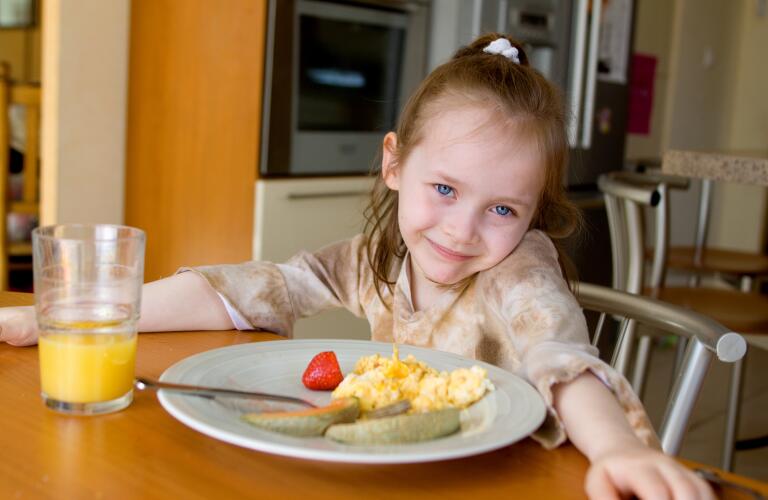 Happy girl at breakfast