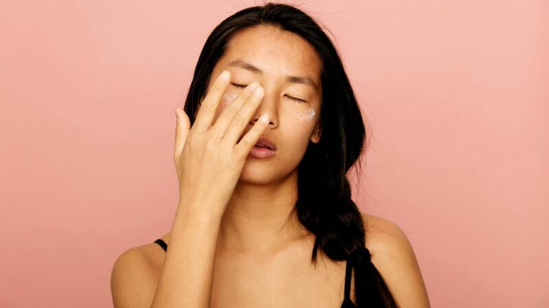 a woman is touching her eyes