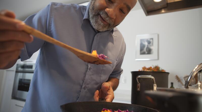 hombre cocinando comida en la estufa