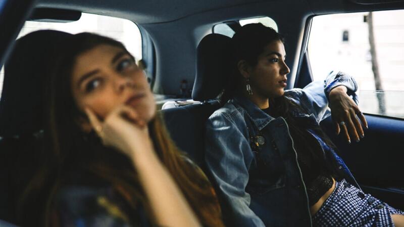 Two people sitting in the backseat of a car