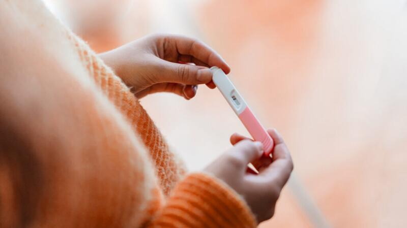 Cropped image of hands holding a positive pregnancy test