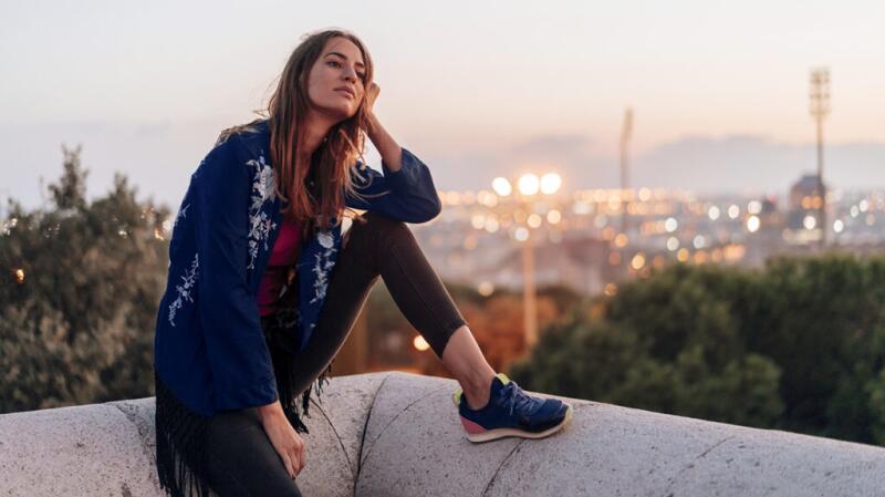 Female sitting on a balcony with her head in her hand