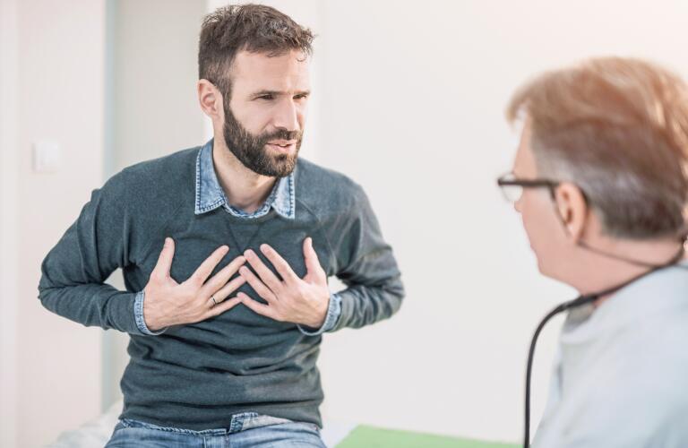 male patient describing chest symptoms to doctor