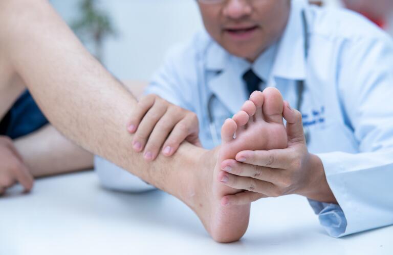 The doctor is examining the patient's foot and toes