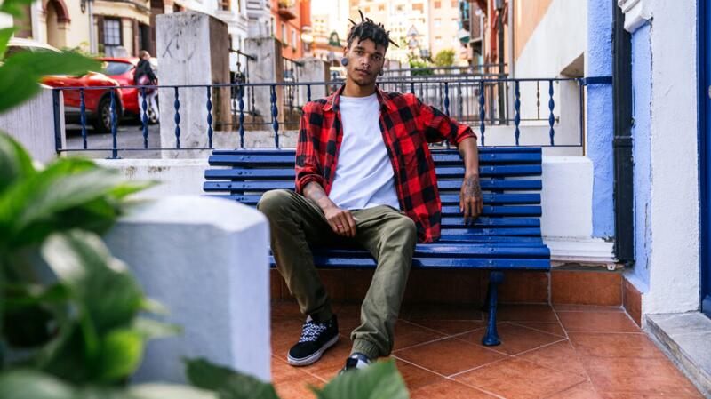 Male sitting outside on a blue bench