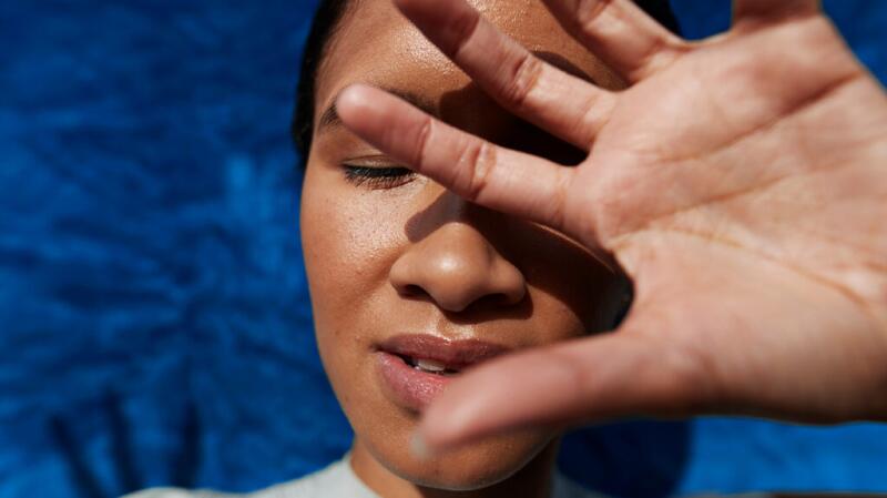 Person covering their face with their hand
