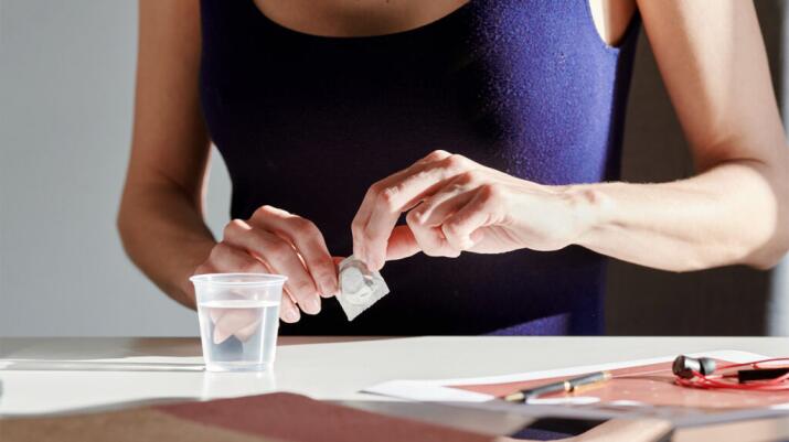 woman opening pill pack