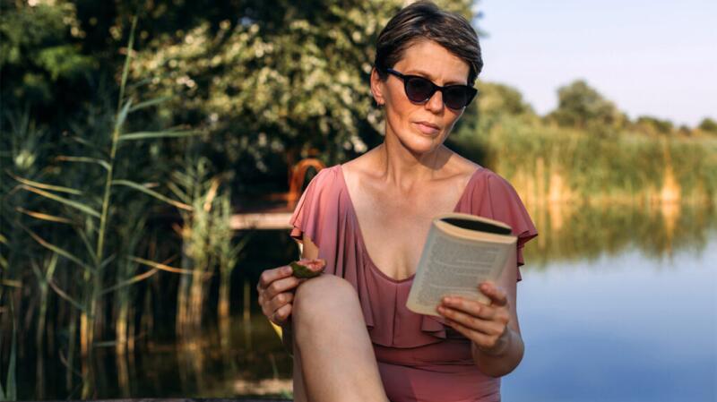 A woman reading a book in the sun