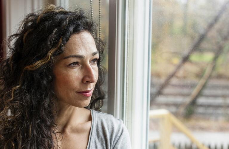 portrait of pensive woman looking out window