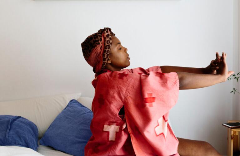Young woman stretching in bed