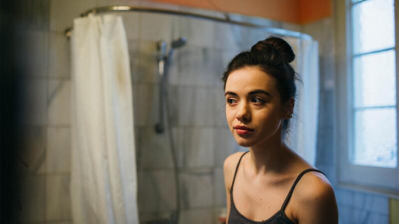 Young woman looking in the mirror